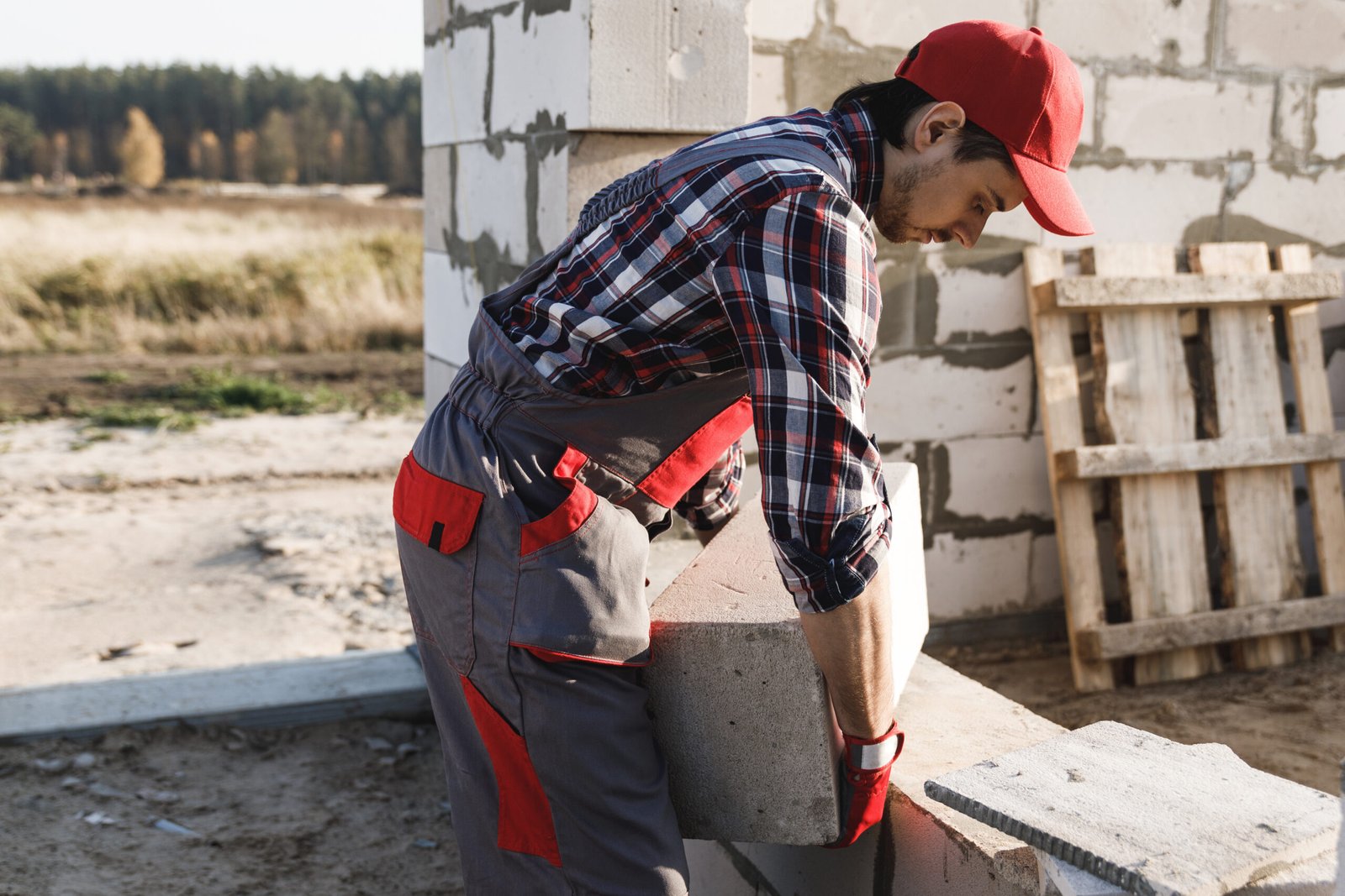 Professional bricklayer is working at the construction site