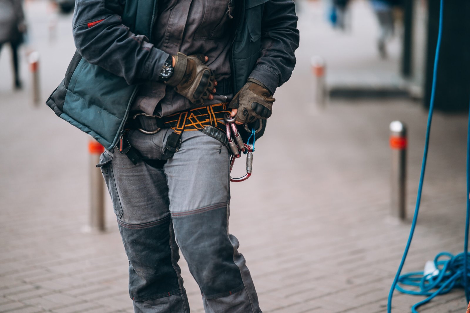 Worker climber preparing for work. Climber tightens the safety belt and check fixing and carbines