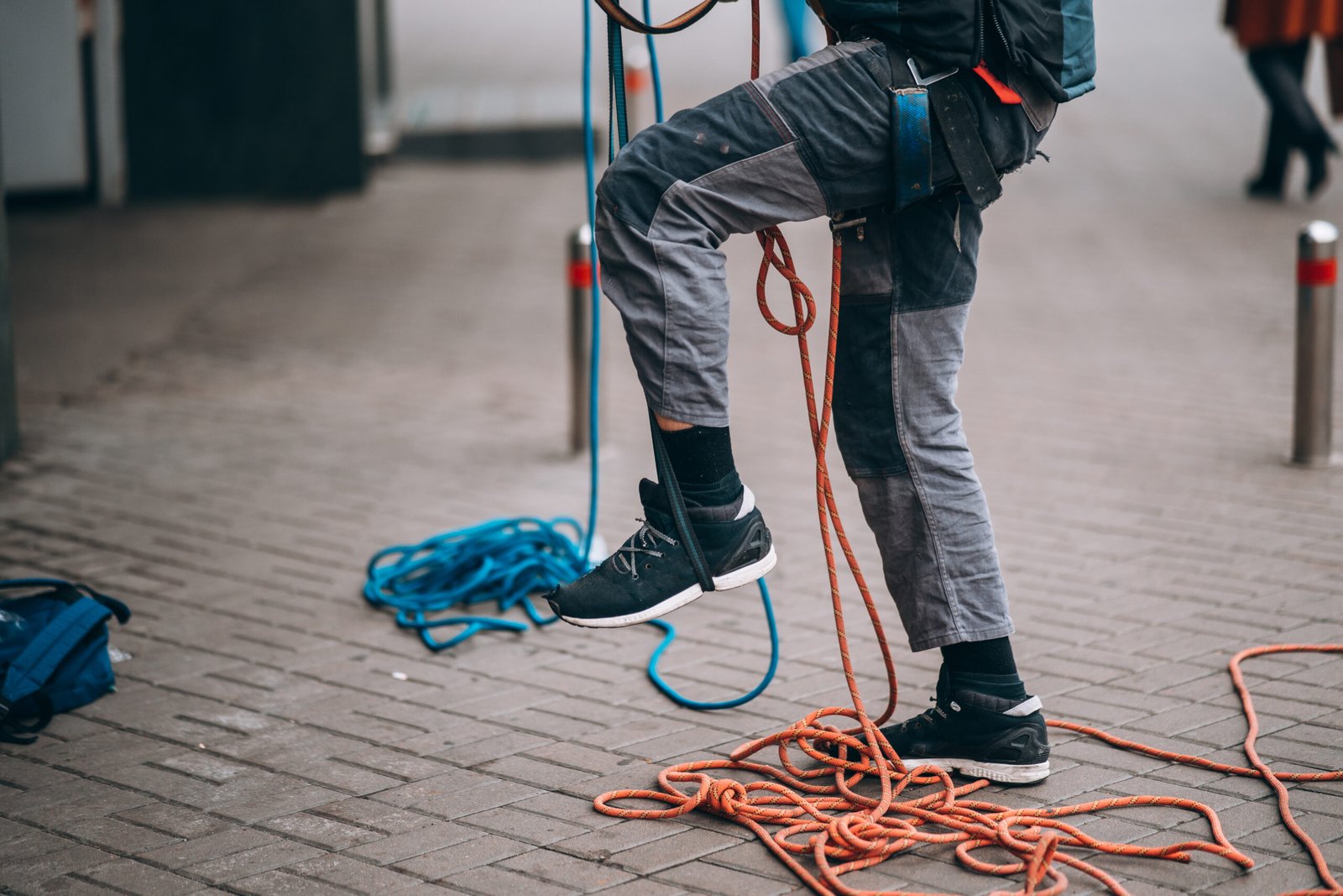 Worker climber preparing for work. Climber tightens the safety belt and check fixing and carbines